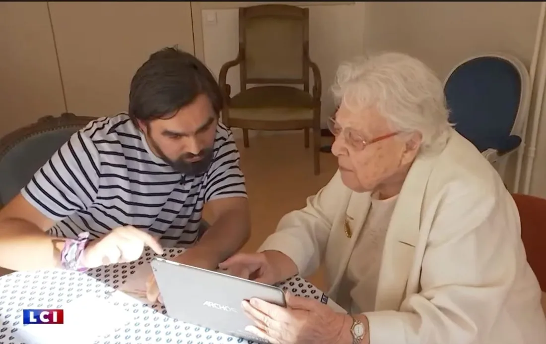 Quentin Le Sellin accompagne une aînée dans l’utilisation de sa tablette